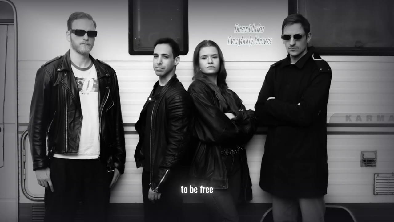 Die vier vor einem Wohnwagen, Schwarzweiß — aus dem Lyric-Video zu „Everybody Knows“