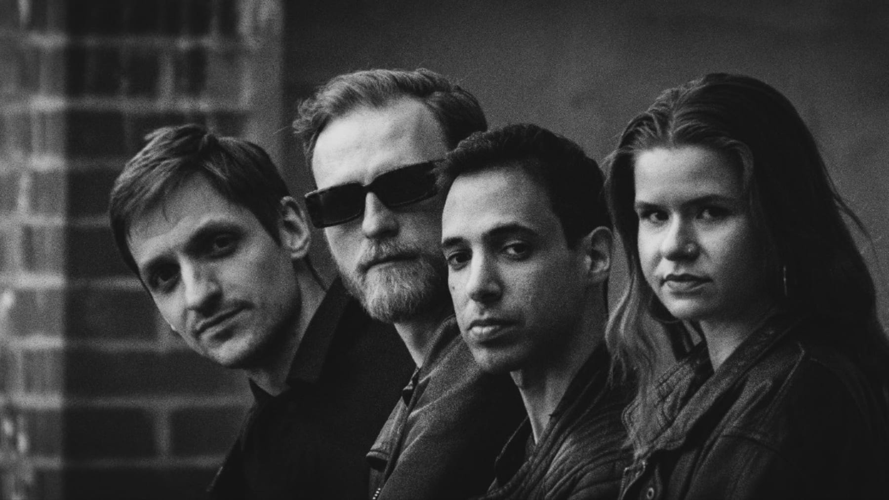 Desert Lake — die vier Bandmitglieder vor einer Backsteinwand, Schwarzweiß