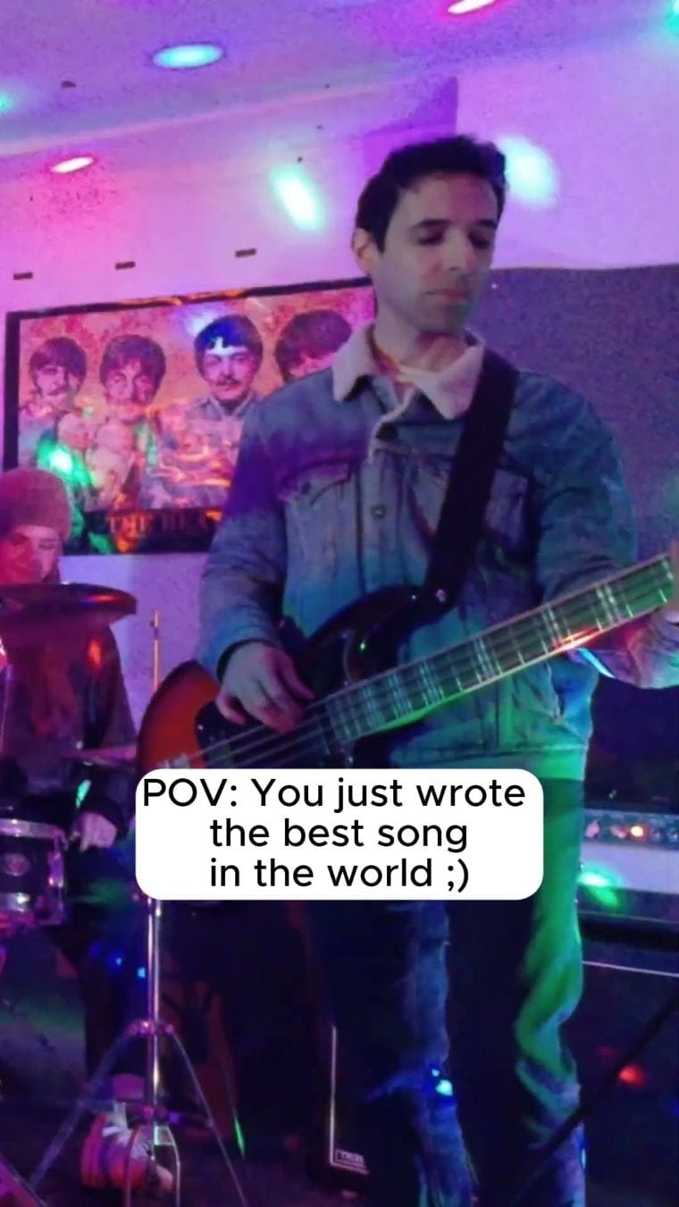 Bassist vor dem Beatles-Bild an der Proberaumwand